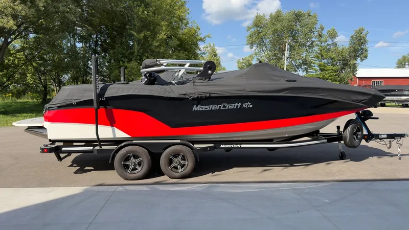 Slide: The Image of A 2021 MasterCraft NXT24 boat on a trailer, covered with a black tarp. - 23