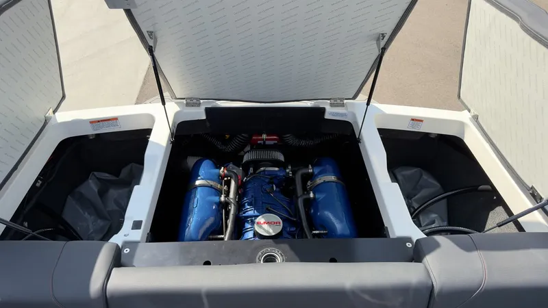 Slide: The Image of The engine compartment of a 2021 MasterCraft NXT24 features a powerful engine with blue covers. - 16