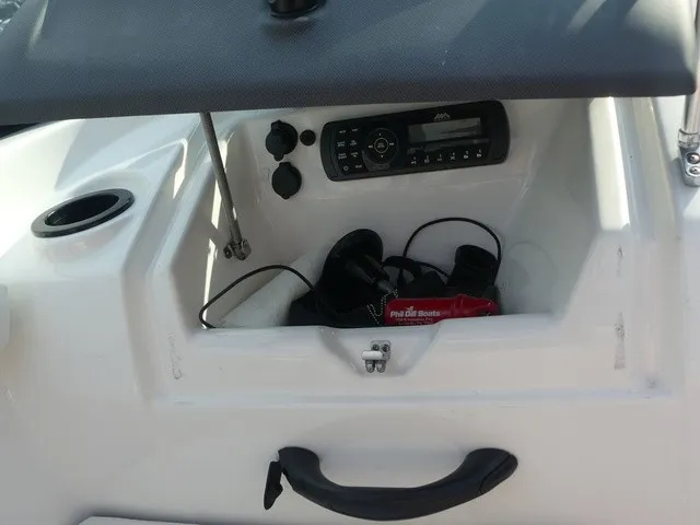 Slide: The Image of An open storage compartment on a Yamaha AR190 boat reveals a radio and headphones. - 24