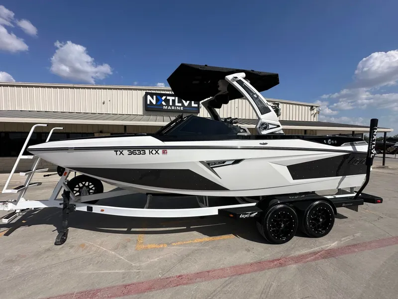 The Image of A white 2024 Tigé 22RZX boat on a trailer in front of a building. - 1