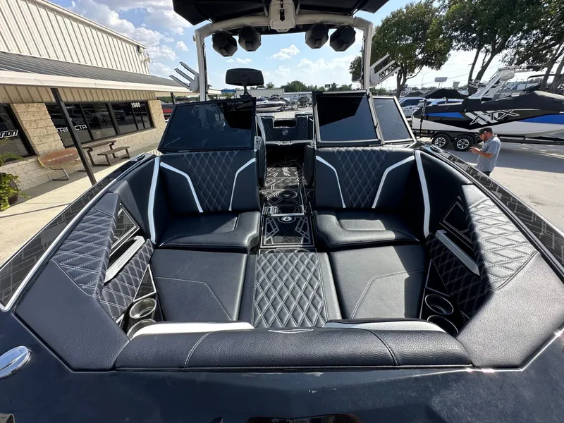 Slide: The Image of The image shows the luxurious cockpit of a 2024 Tigé 22RZX boat with black upholstery. - 26