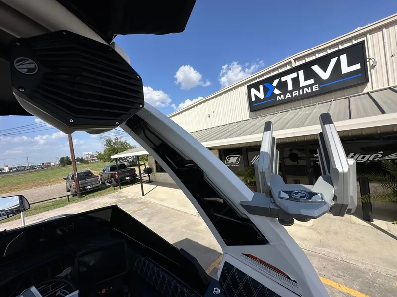 Slide: The Image of A modern boat with speakers and mounts, in front of a building labeled "NXT LVL Marine." - 30