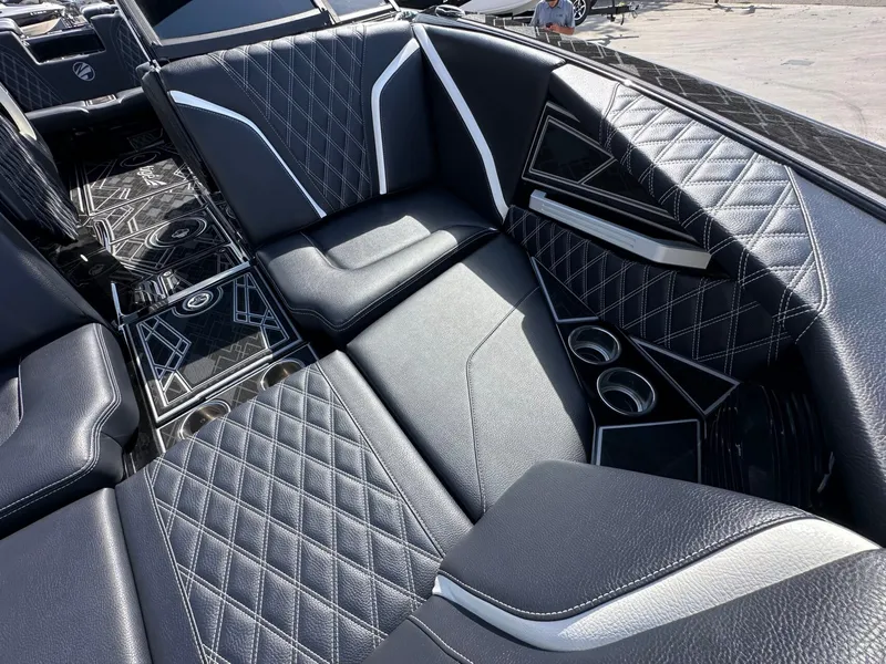 Slide: The Image of The image shows luxurious black upholstered seats with white stitching and cup holders on a boat. - 25