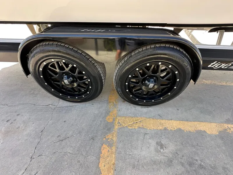 Slide: The Image of Black dual wheels on a boat trailer, parked on a concrete surface. - 35