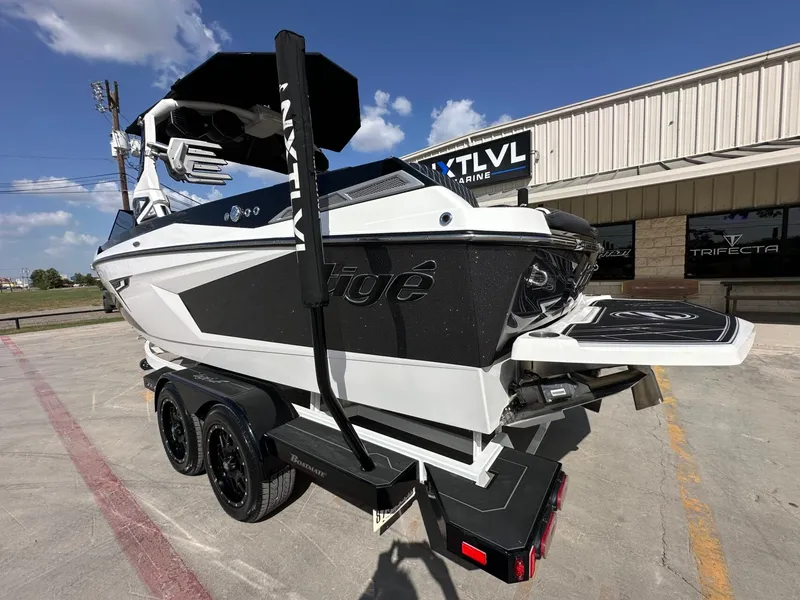 Slide: The Image of A 2024 Tigé 22RZX boat on a trailer, featuring a sleek design and black finish. - 3