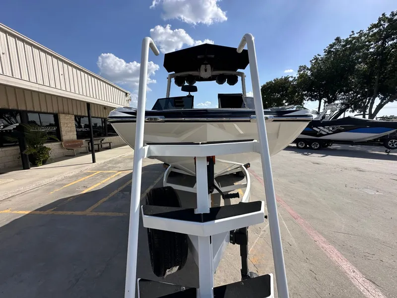 Slide: The Image of A 2024 Tigé 22RZX boat on a trailer in a parking lot, surrounded by buildings and trees. - 9
