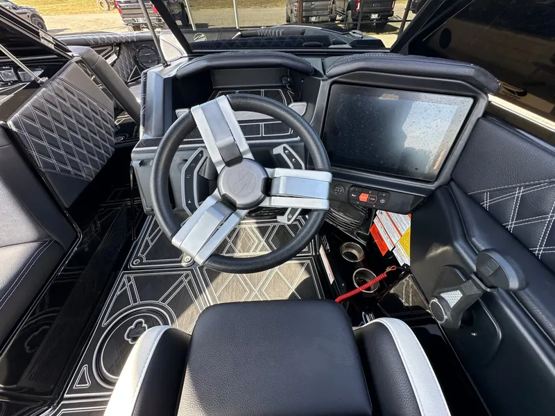 Slide: The Image of The image shows the cockpit of a 2024 Tigé 22RZX boat with a modern steering wheel and large display. - 19
