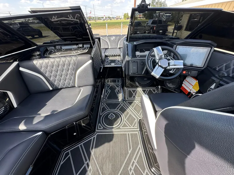 Slide: The Image of The image shows the interior of a 2024 Tigé 22RZX boat with modern black seating and a stylish steering wheel. - 17