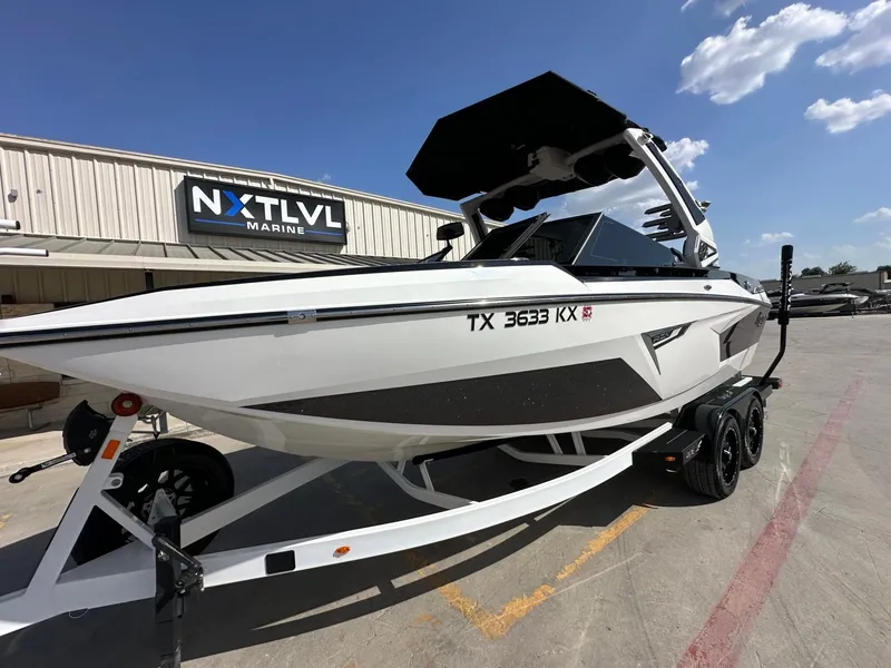 Slide: The Image of A white 2024 Tigé 22RZX boat on a trailer in front of a building with "NXT LVL Marine" sign. - 10