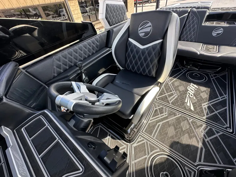 Slide: The Image of The image shows the cockpit of a 2024 Tigé 22RZX boat with luxurious black seating and a modern steering wheel. - 27