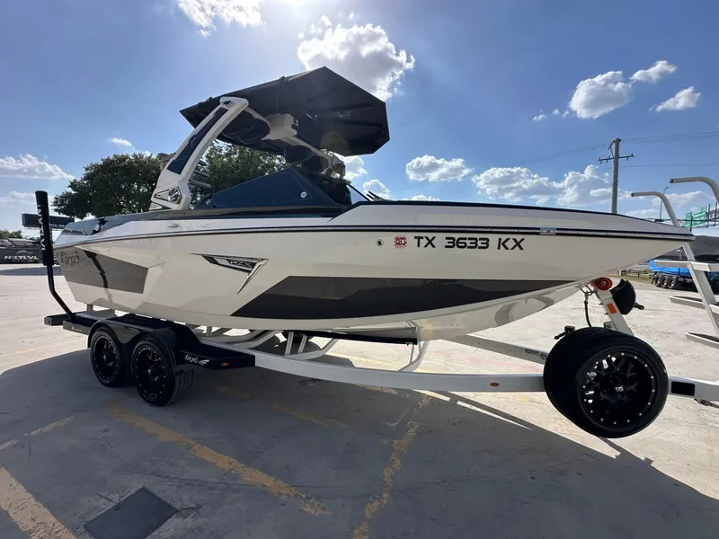 Slide: The Image of A white 2024 Tigé 22RZX boat on a trailer under a sunny sky. - 8