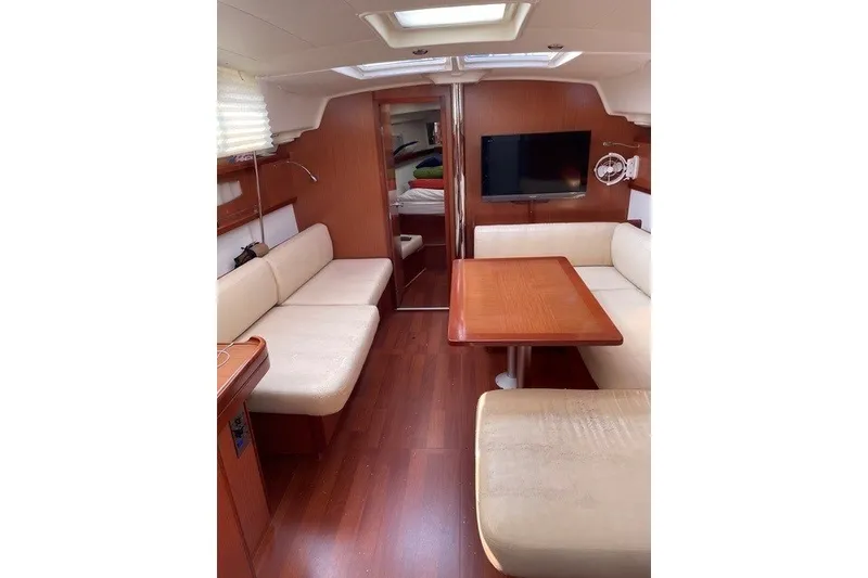 Slide: The Image of Interior of 2011 Beneteau Oceanis 43 yacht with cozy seating and wooden table. - 3