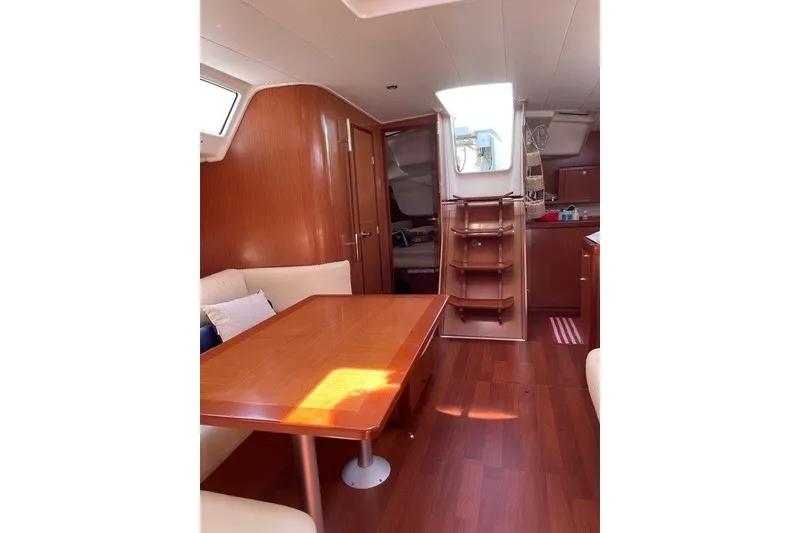 Slide: The Image of Interior of 2011 Beneteau Oceanis 43 sailboat with wooden furnishings and cozy seating area. - 6
