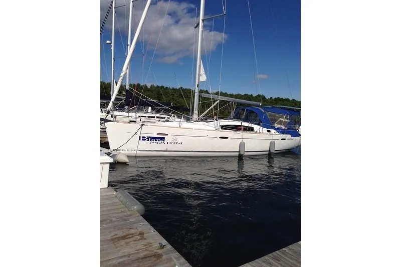 Slide: The Image of 2011 Beneteau Oceanis 43 sailboat docked at marina under clear blue sky. - 2