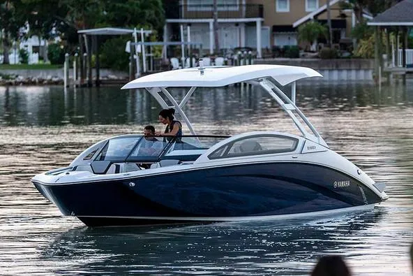 Slide: The Image of Manufacturer Provided Image: 2020 Yamaha Boats 275SD cruising on calm waters near a residential area. - 13