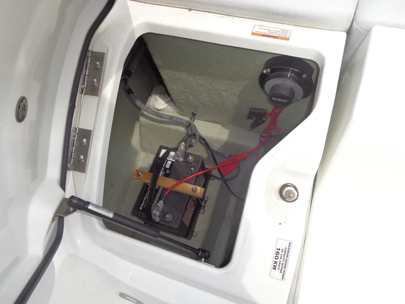 Slide: The Image of An open storage compartment in the boat reveals a battery with cables and a switch. - 27