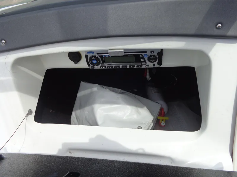 Slide: The Image of An open storage compartment with a radio and a white bag inside. - 32