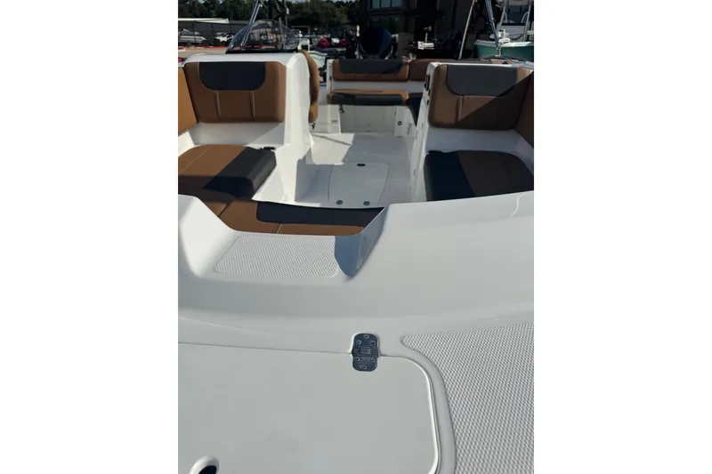Slide: The Image of 2027 Tahoe 2150 boat interior with brown and black seating, docked at marina. - 6