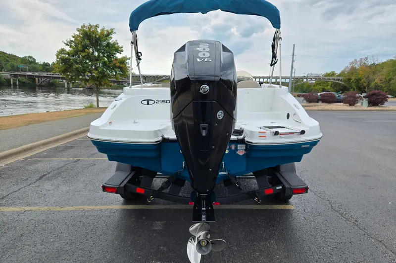 Slide: The Image of 2027 Tahoe 2150 boat with outboard motor, parked near a scenic waterfront. - 6