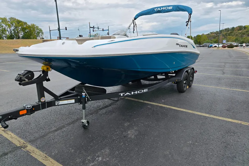 Slide: The Image of 2027 Tahoe 2150 boat on trailer in parking lot, featuring sleek blue and white design. - 3