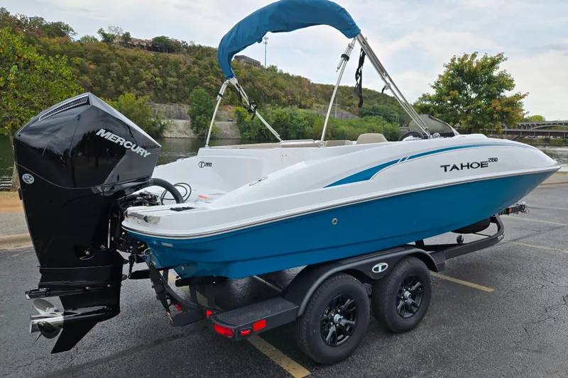 Slide: The Image of 2027 Tahoe 2150 boat with Mercury engine on trailer, parked near a scenic river. - 8