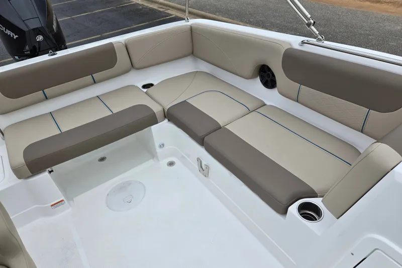 Slide: The Image of 2027 Tahoe 2150 boat interior with beige and brown seating, featuring cup holders and speaker. - 16