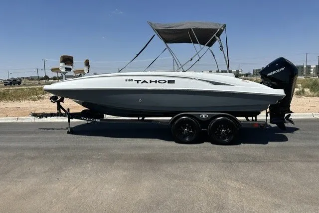 The Image of 2027 Tahoe 2150 boat on trailer, parked on road under clear blue sky. - 0