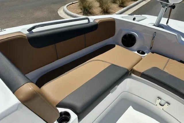 Slide: The Image of 2027 Tahoe 2150 boat interior with tan and black seating, cup holders, and speaker. - 15