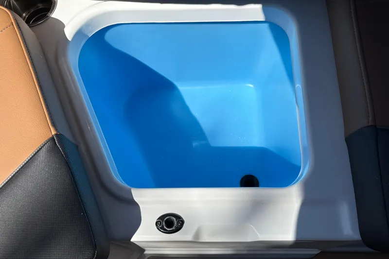 Slide: The Image of 2027 Tahoe 210 S boat interior with blue storage compartment and cup holder. - 40