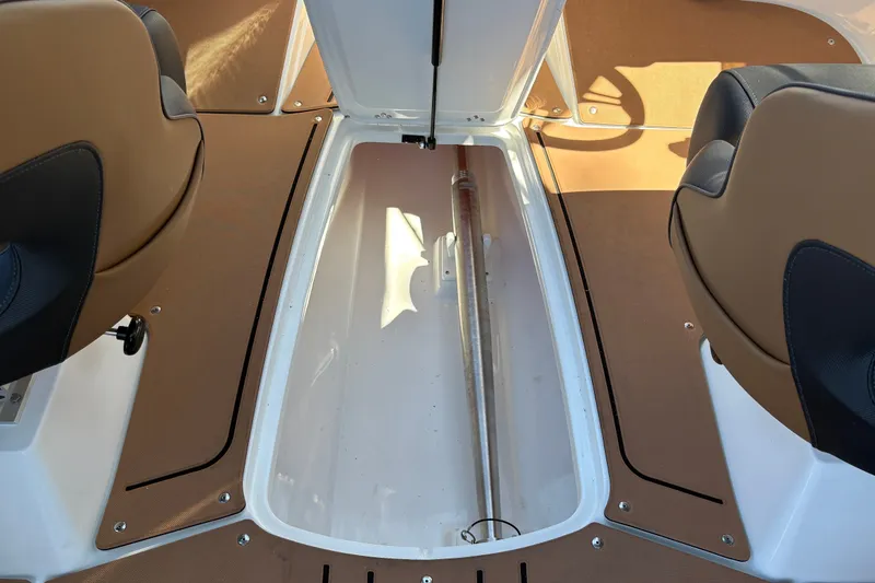 Slide: The Image of 2027 Tahoe 210 S boat interior storage compartment with brown seating. - 51