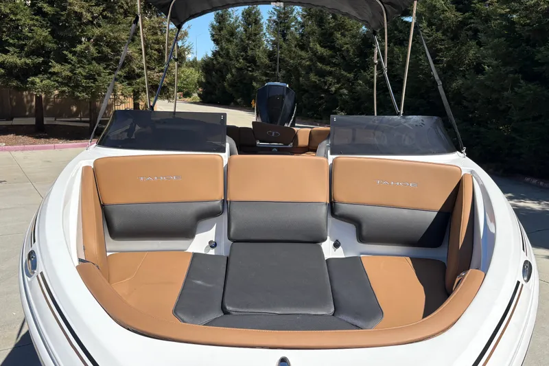 Slide: The Image of 2027 Tahoe 210 S boat with tan and black seating, parked outdoors. - 14
