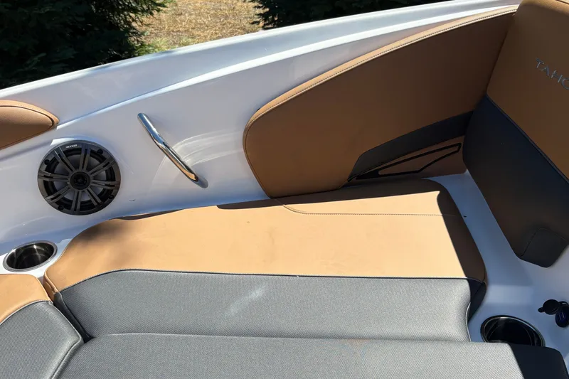 Slide: The Image of 2027 Tahoe 210 S boat interior with tan and gray seating, speaker, and cup holder. - 29