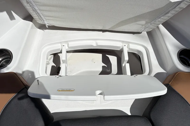 Slide: The Image of 2027 Tahoe 210 S boat storage compartment with open lid and cup holders. - 28