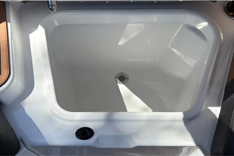 Slide: The Image of 2027 Tahoe 210 S boat interior compartment with drain plug. - 33