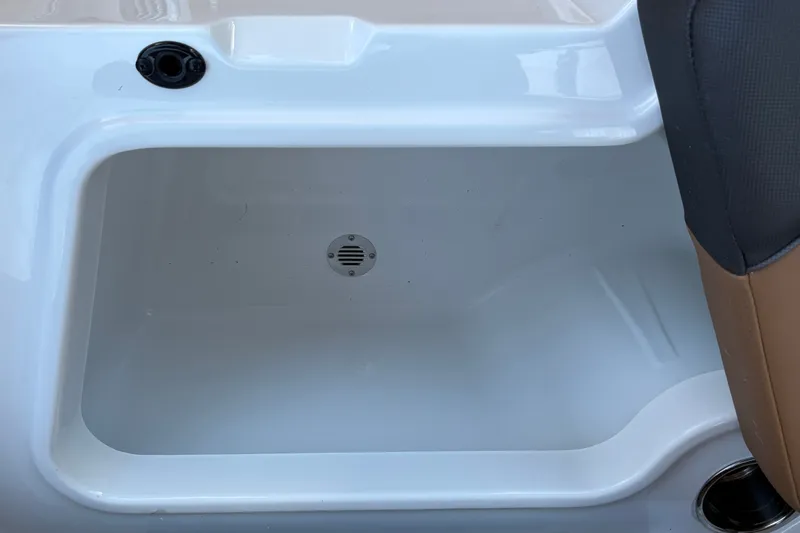 Slide: The Image of Storage compartment in 2027 Tahoe 210 S boat, featuring a drain and sleek design. - 32