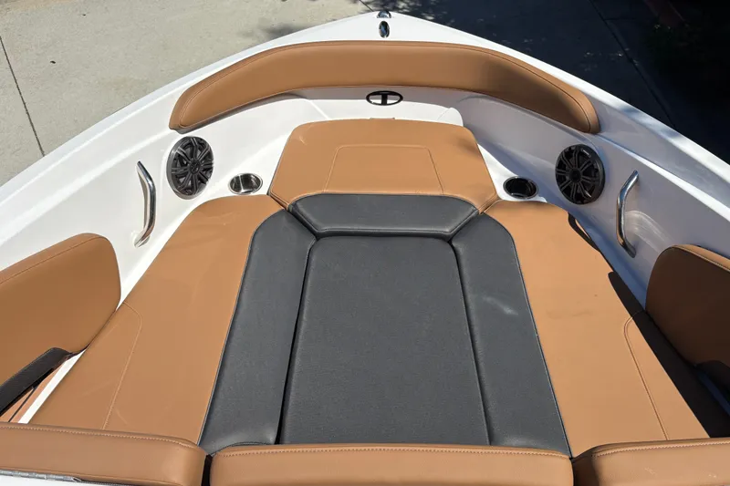 Slide: The Image of 2027 Tahoe 210 S boat interior with tan and black seating, speakers, and cup holders. - 52