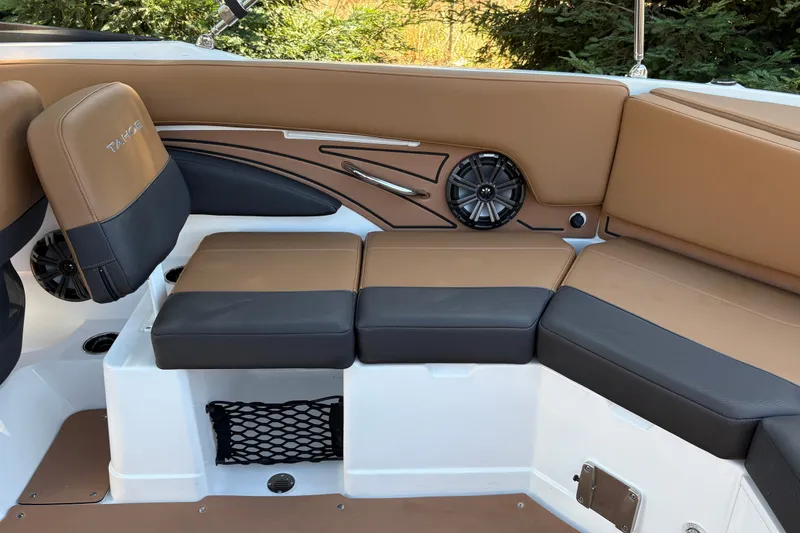 Slide: The Image of 2027 Tahoe 210 S boat interior with tan and black seating, speaker, and storage net. - 24
