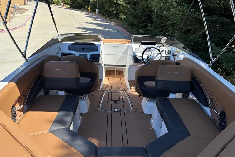 Slide: The Image of 2027 Tahoe 210 S boat interior with tan and black seating, steering wheel, and dashboard. - 20