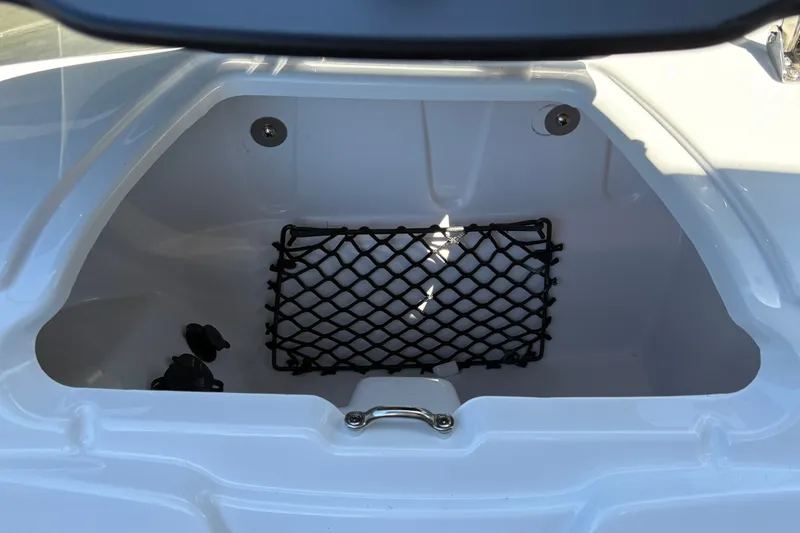 Slide: The Image of Storage compartment of 2027 Tahoe 210 S boat with netting and latch. - 31