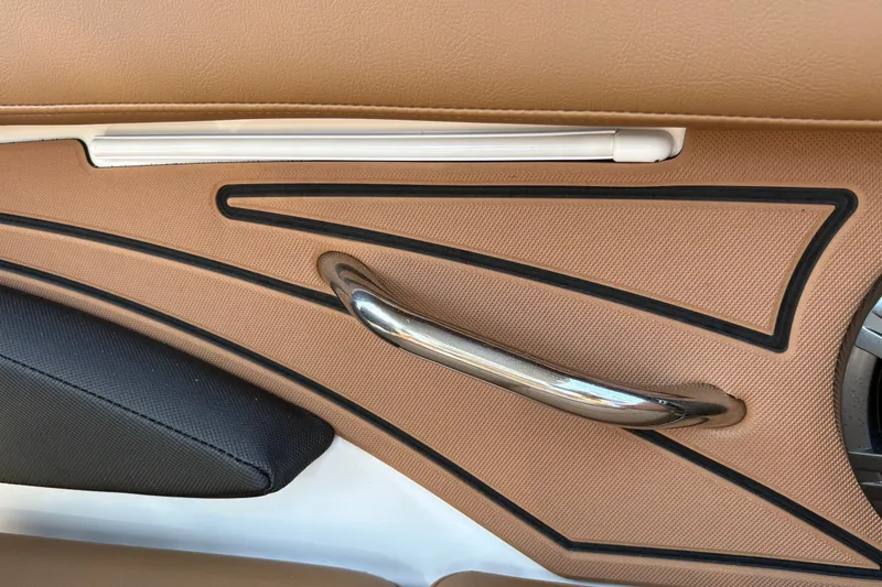 Slide: The Image of Interior detail of 2027 Tahoe 210 S boat, featuring sleek tan and black design elements. - 22