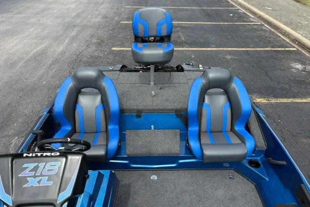 Slide: The Image of 2027 Nitro Z18 XL Pro boat with blue and gray seating, parked on asphalt. - 16