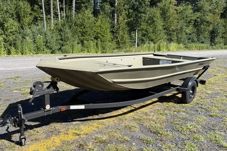 The Image of 2027 Tracker Grizzly 1754 Utility boat on trailer, parked outdoors. - 0