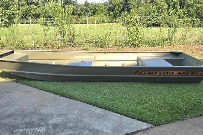 The Image of 2027 Tracker Grizzly 15 Jon boat on grass, showcasing sleek design and durable construction. - 0
