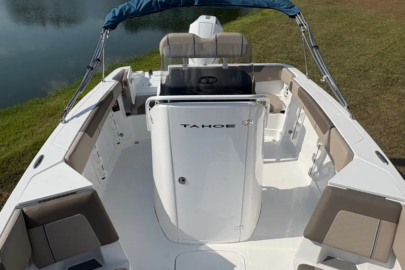 Slide: The Image of 2027 Tahoe 2150 CC boat with spacious seating, docked by a serene lake. - 11