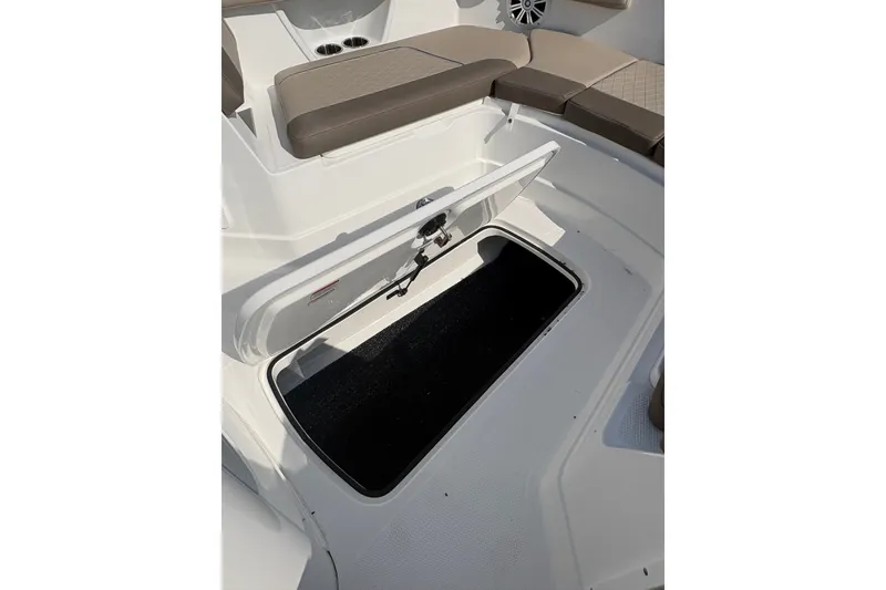 Slide: The Image of Open storage compartment on 2027 Tahoe 2150 CC boat, featuring cushioned seating. - 12