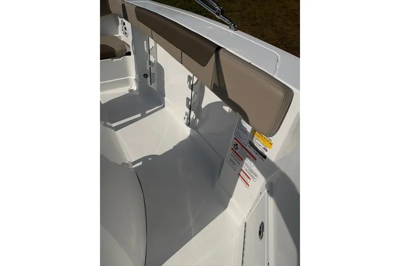 Slide: The Image of 2027 Tahoe 2150 CC boat interior with beige seating and safety labels. - 14