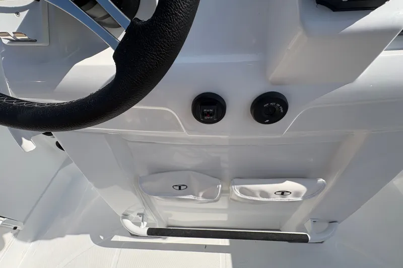 Slide: The Image of Steering console of a 2027 Tahoe 2150 CC boat with controls and storage pockets. - 23