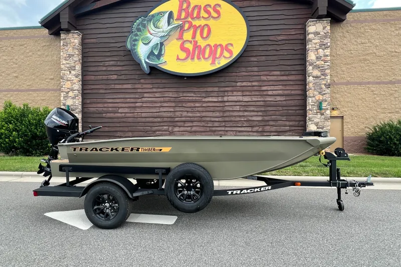 The Image of 2027 Tracker Grizzly 1553 Timber boat on trailer outside Bass Pro Shops. - 0