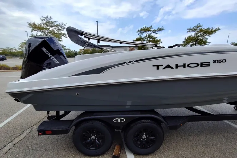Slide: The Image of 2027 Tahoe 2150 boat on trailer with Mercury engine in parking lot. - 1