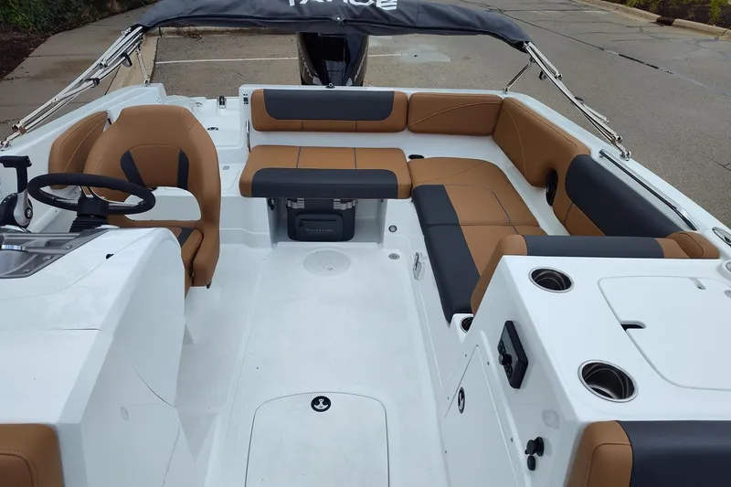 Slide: The Image of 2027 Tahoe 2150 boat interior with tan and black seating, steering wheel, and cup holders. - 7